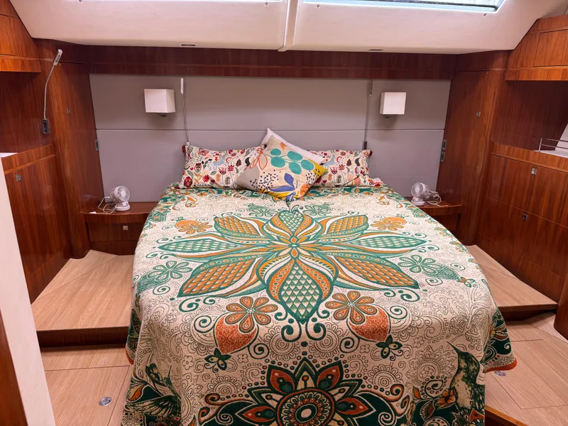 Slide: The Image of Luxurious Amel 55 yacht bedroom with vibrant floral bedding, wood paneling, and modern lighting. - 16