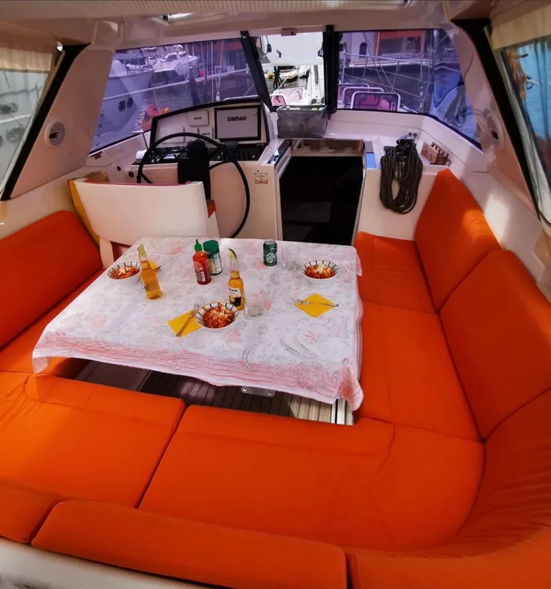 Slide: The Image of Interior of 2012 Amel 55 yacht with orange seating and dining setup. - 5