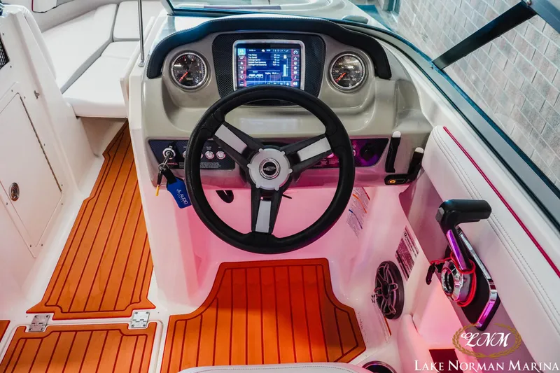 Slide: The Image of 2018 Chaparral 21 Surf boat dashboard with steering wheel and control panel. - 14