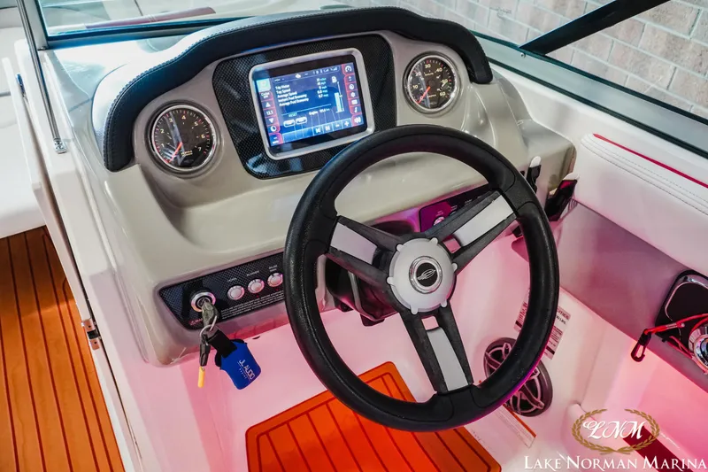 Slide: The Image of 2018 Chaparral 21 Surf boat dashboard with steering wheel and digital display. - 15