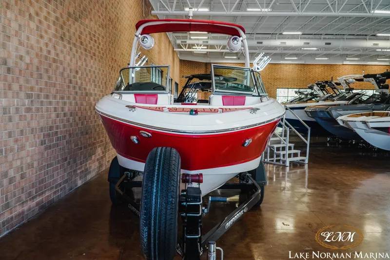Slide: The Image of 2018 Chaparral 21 Surf boat in showroom, red and white exterior, displayed at Lake Norman Marina. - 4
