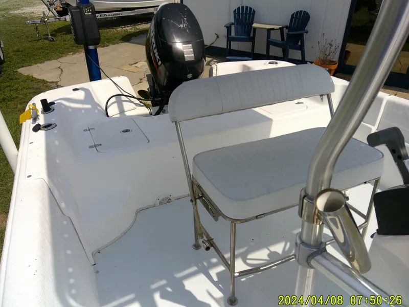 Slide: The Image of 2010 Carolina Skiff 198 DLV boat interior with seating and motor, photographed outdoors. - 11