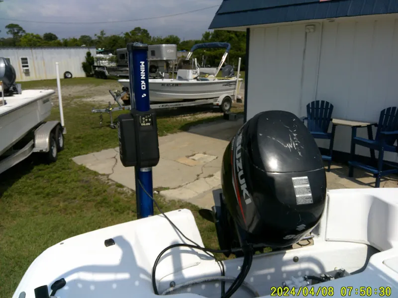 Slide: The Image of 2010 Carolina Skiff 198 DLV with Suzuki outboard motor in a boatyard. - 12