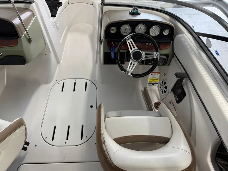 Slide: The Image of 2009 Four Winns H200 boat interior with steering wheel and dashboard gauges. - 12