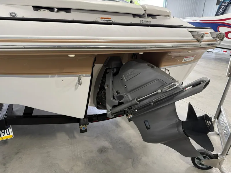 Slide: The Image of 2009 Four Winns H200 boat stern with outboard motor in a garage setting. - 6