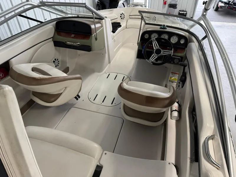 Slide: The Image of 2009 Four Winns H200 boat interior with beige seating and steering console. - 8