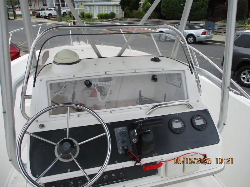 Slide: The Image of 1995 Wellcraft 218ccf boat dashboard with steering wheel and gauges, parked in a residential area. - 10
