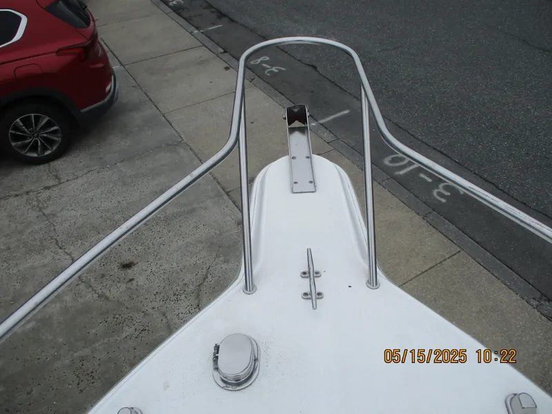 Slide: The Image of Bow of 1995 Wellcraft 218ccf boat with metal railings, parked near a red car. - 14
