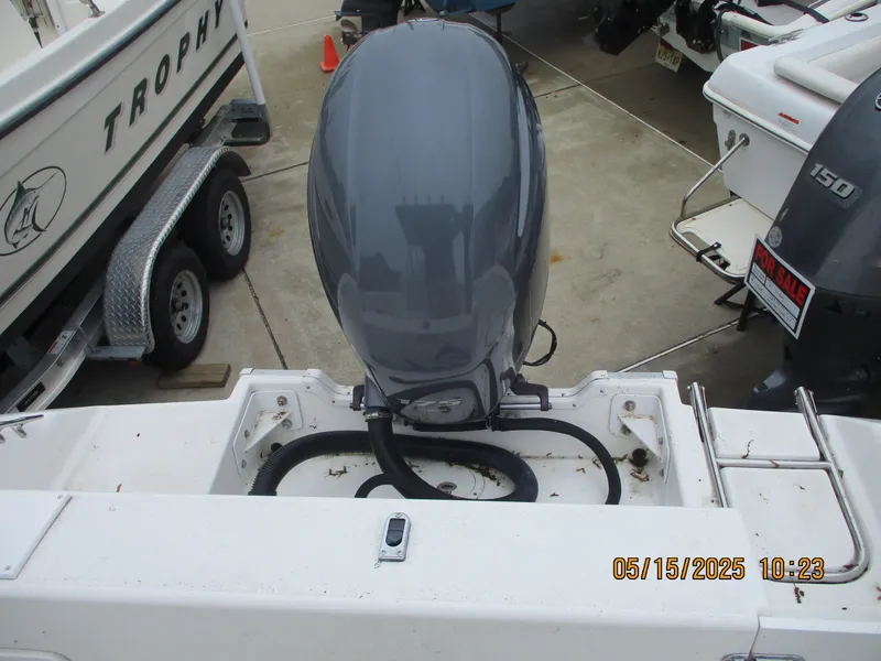 Slide: The Image of 1995 Wellcraft 218ccf boat with outboard motor, docked near other boats. - 16