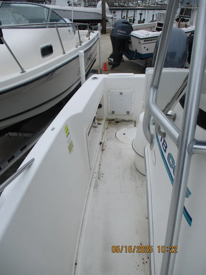 Slide: The Image of 1995 Wellcraft 218ccf boat deck, white interior, docked beside other boats. - 17