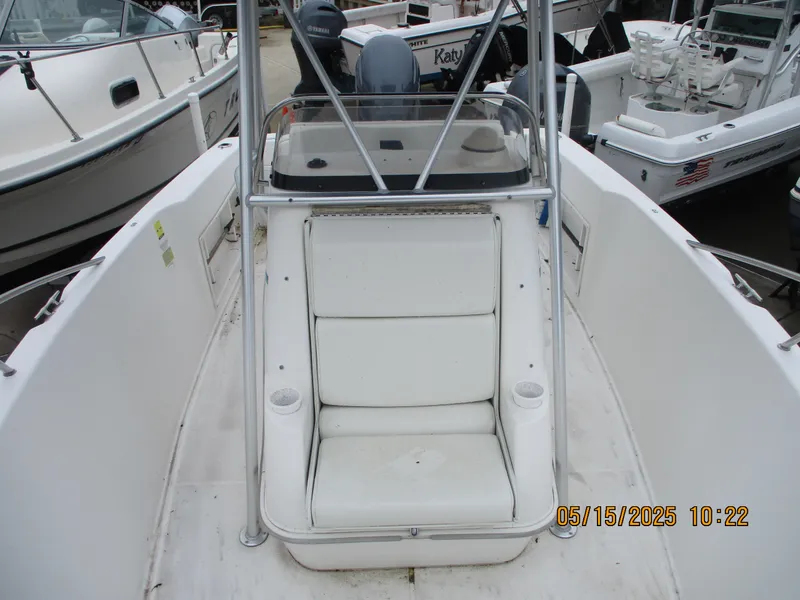 Slide: The Image of 1995 Wellcraft 218ccf boat with white seating and console, docked among other boats. - 18