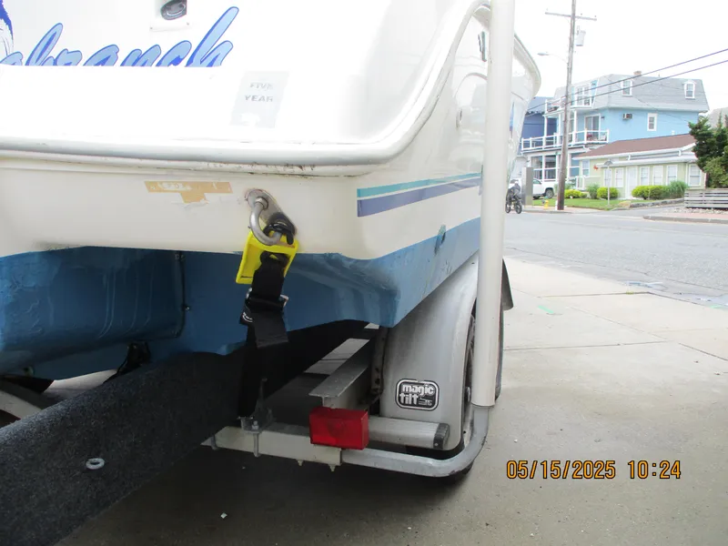 Slide: The Image of 1995 Wellcraft 218ccf boat on trailer, secured with strap, parked in residential area. - 27