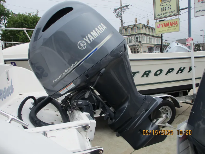 Slide: The Image of Yamaha outboard motor on a 1995 Wellcraft 218ccf boat, parked near a Trophy boat. - 6