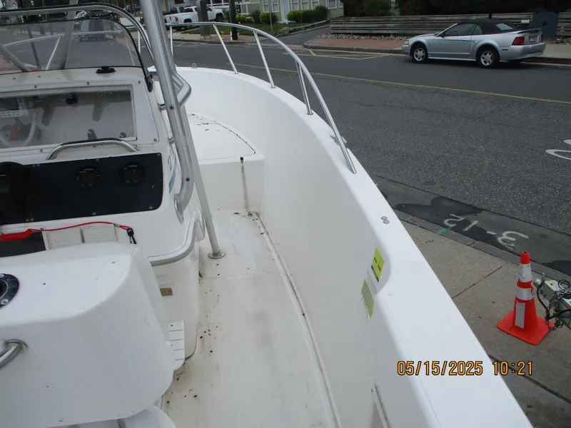 Slide: The Image of 1995 Wellcraft 218ccf boat docked on a street, interior view with console and railing. - 7