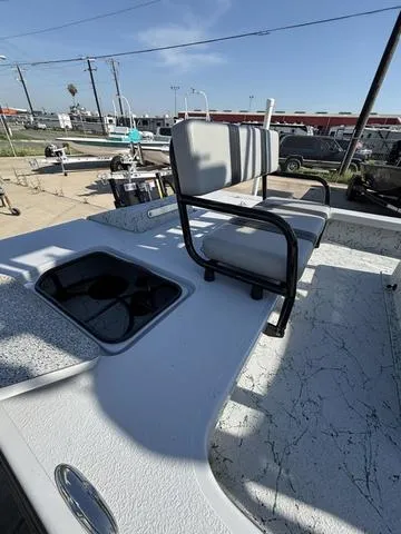 Slide: The Image of 2024 Majek 24 Reaper boat with seating and storage compartments, parked outdoors. - 6