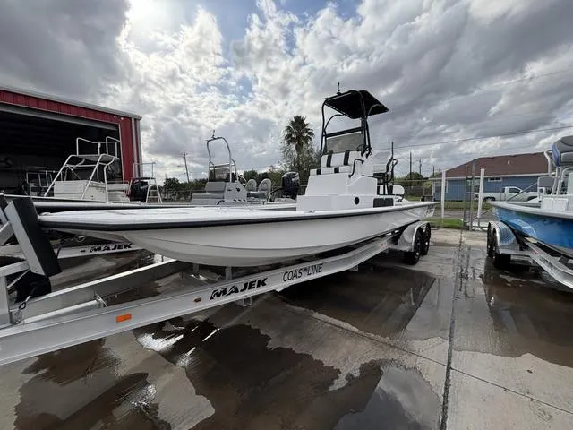 Slide: The Image of 2024 Majek 25 ILLUSION boat on trailer, parked outdoors under cloudy sky. - 3
