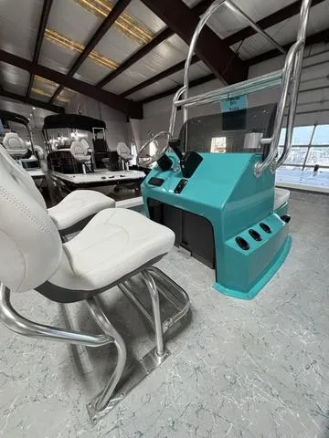 Slide: The Image of 2024 Majek 2206 Illusion boat interior with teal console and white seating in showroom. - 4