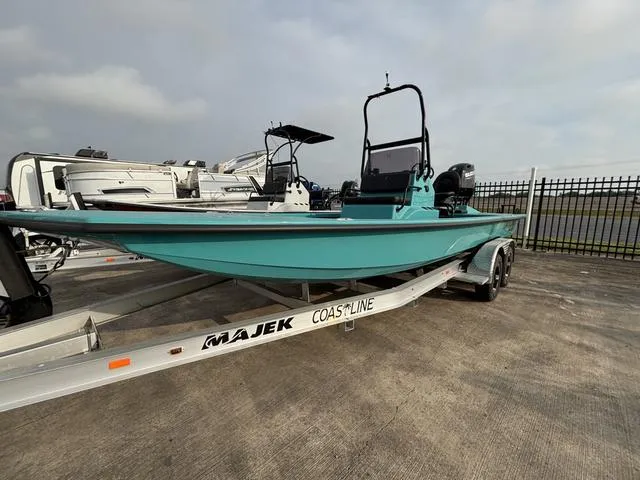 Slide: The Image of 2025 Majek 2206 Illusion boat on trailer, teal color, parked outdoors. - 1