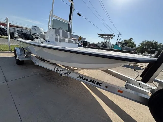 Slide: The Image of 2025 Majek 18 M2 boat on trailer, parked outdoors under clear sky. - 1