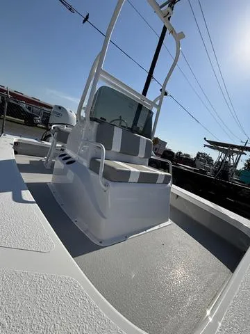 Slide: The Image of 2025 Majek 18 M2 boat with center console and seating, docked under clear sky. - 3