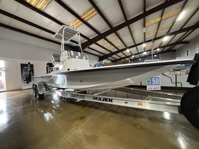 Slide: The Image of 2025 Majek 24 Reaper boat displayed indoors on a trailer. - 1