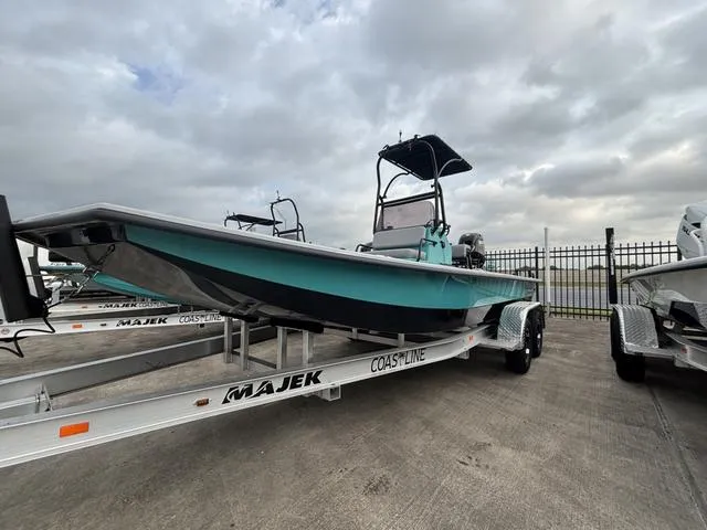 Slide: The Image of 2025 Majek 21 RFL boat on trailer, parked outdoors under cloudy sky. - 1