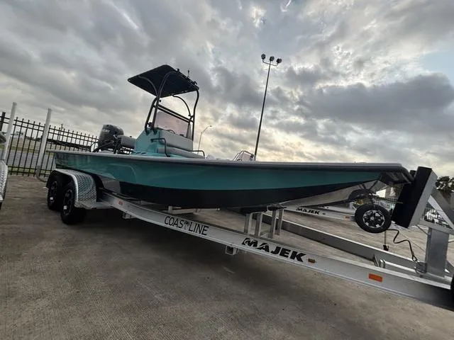 Slide: The Image of 2025 Majek 21 RFL boat on trailer under cloudy sky. - 2