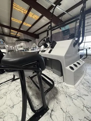 Slide: The Image of 2025 Majek 21 RFL boat interior with modern console and seating in a showroom. - 7