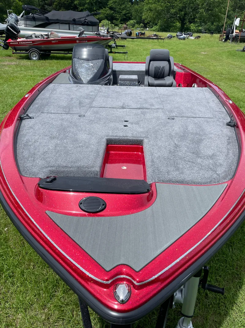 Slide: The Image of 2025 Falcon Boats F215, red and gray, parked on grass. - 2