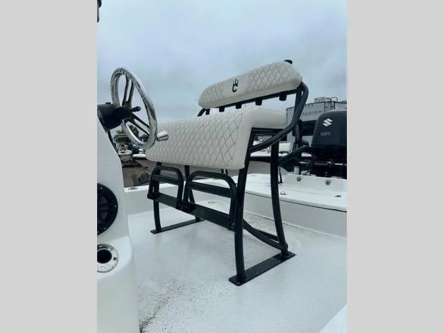 Slide: The Image of 2023 Catalyst Boat Works 2200 CAT helm seat with steering wheel, featuring diamond-pattern upholstery. - 10
