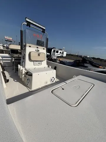 Slide: The Image of 2024 Carolina Skiff E18 JVX CC boat with center console, docked under clear blue sky. - 4