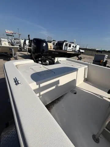 Slide: The Image of 2024 Carolina Skiff E18 JVX CC boat with outboard motor, displayed in a marina setting. - 5