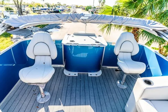 Slide: The Image of 2025 Starcraft EX20FD boat interior with white seats and blue accents. - 11