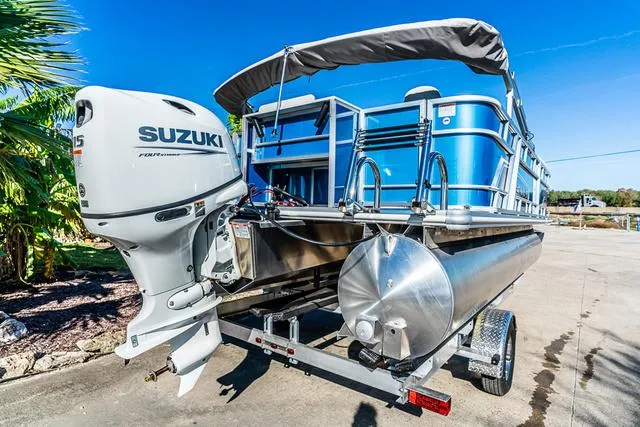 Slide: The Image of 2025 Starcraft EX20FD pontoon boat with Suzuki outboard motor on a trailer. - 7
