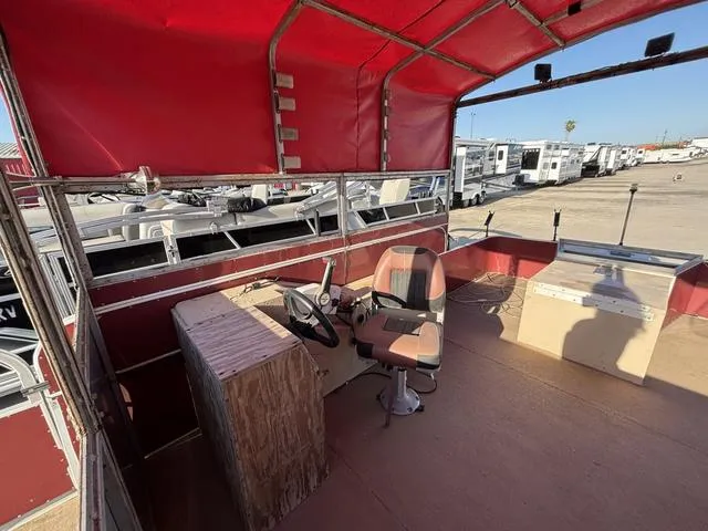 Slide: The Image of Interior of a 1999 Landau 20 boat with red canopy and steering console. - 6