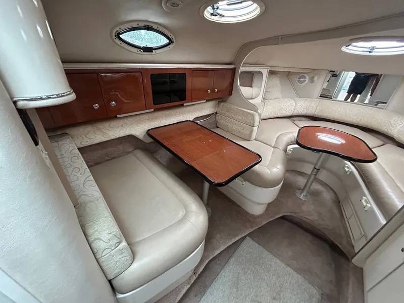 Slide: The Image of Luxurious interior of a 2003 Monterey 302 Cruiser with elegant seating and wooden tables. - 16