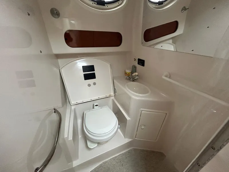 Slide: The Image of 2003 Monterey 302 Cruiser bathroom with toilet, sink, and porthole windows. - 19