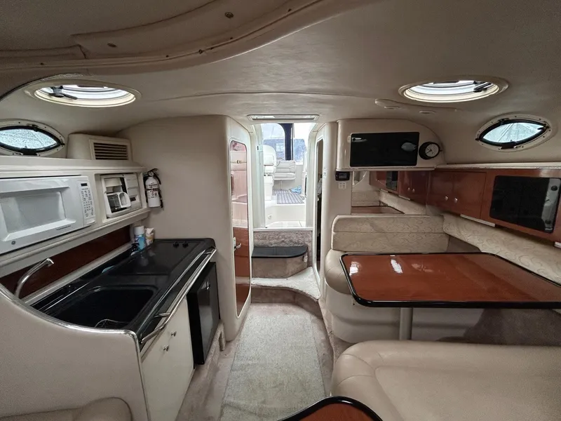 Slide: The Image of Interior of a 2003 Monterey 302 Cruiser featuring a compact kitchen and dining area. - 21