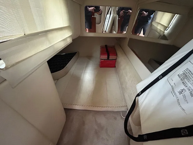 Slide: The Image of Interior cabin of a 2003 Monterey 302 Cruiser with beige upholstery and a red bag. - 23