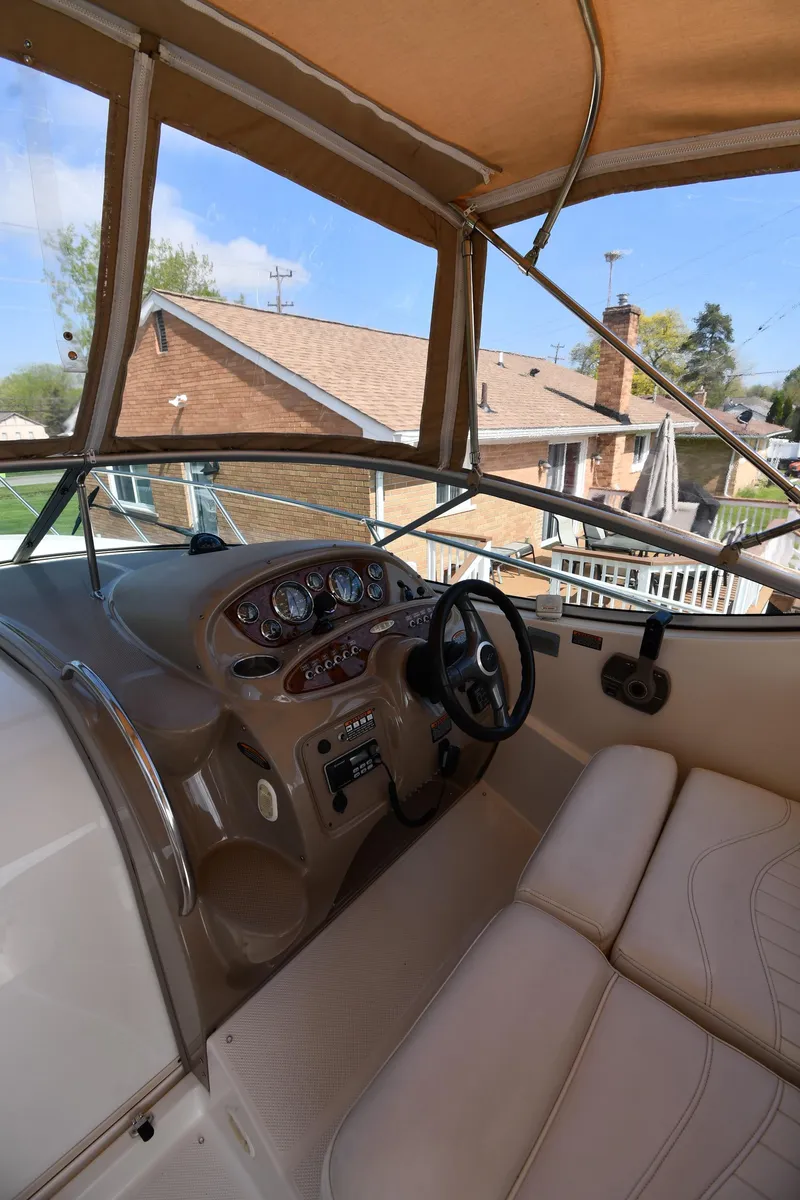 Slide: The Image of 2000 Maxum 2700 SCR boat cockpit with steering wheel and beige seating. - 12