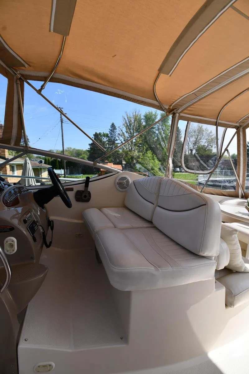 Slide: The Image of Interior view of 2000 Maxum 2700 SCR boat with beige seating and canopy. - 17