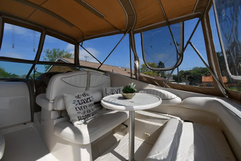 Slide: The Image of 2000 Maxum 2700 SCR boat interior with cushioned seating, table, and decorative pillows. - 19