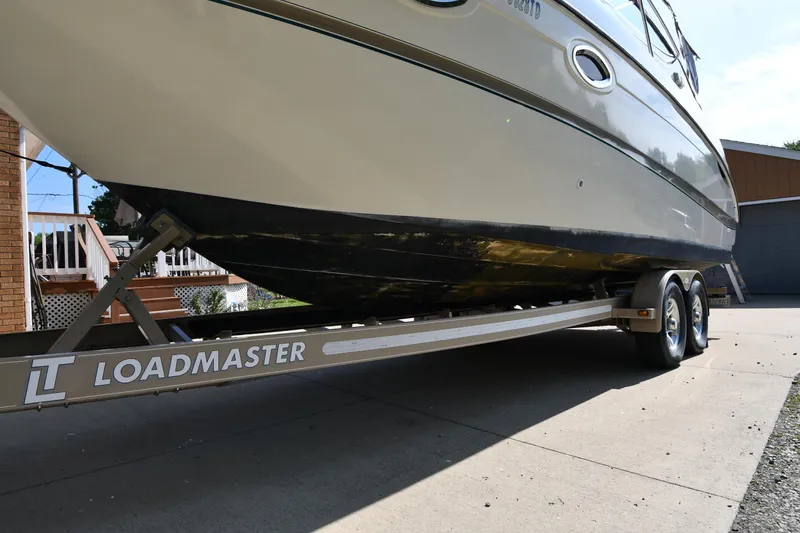 Slide: The Image of 2000 Maxum 2700 SCR boat on Loadmaster trailer, parked on driveway. - 2