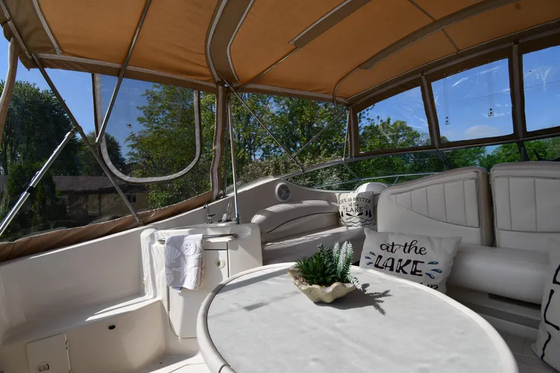Slide: The Image of Interior of 2000 Maxum 2700 SCR boat with seating and table under canopy. - 21
