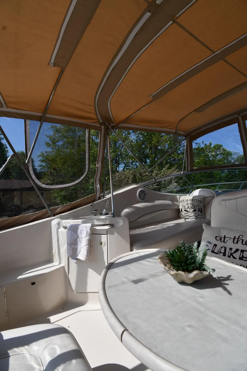 Slide: The Image of 2000 Maxum 2700 SCR boat interior with seating, table, and canopy. - 22