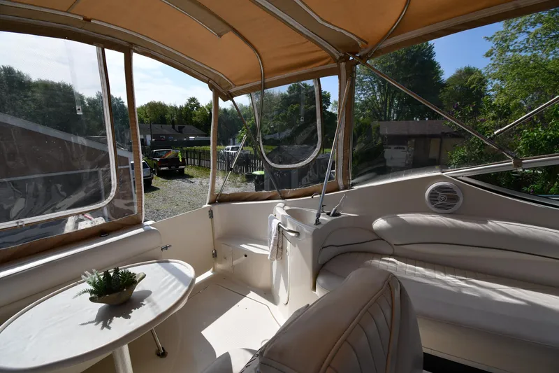 Slide: The Image of 2000 Maxum 2700 SCR boat interior with seating and table under canopy. - 23