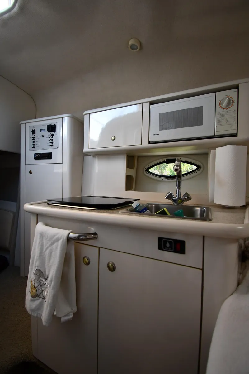 Slide: The Image of 2000 Maxum 2700 SCR boat kitchen with microwave, sink, and storage cabinets. - 34