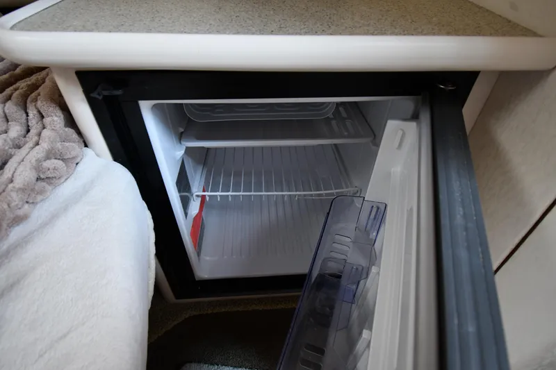 Slide: The Image of Small refrigerator inside a 2000 Maxum 2700 SCR boat cabin, open and empty. - 38