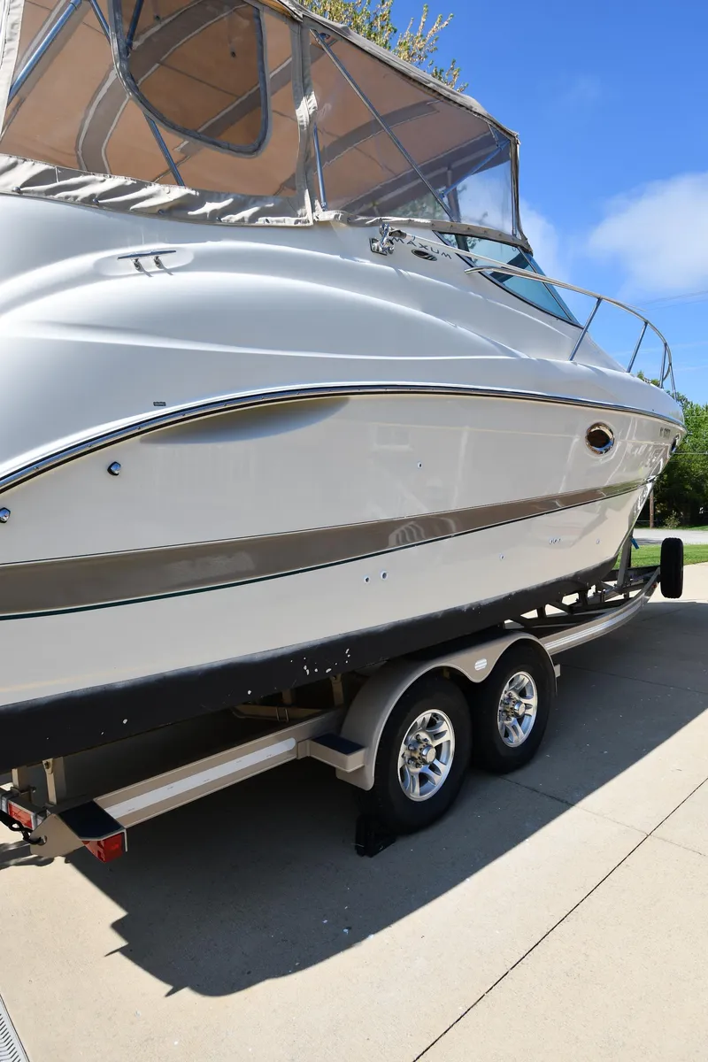 Slide: The Image of 2000 Maxum 2700 SCR boat on trailer, sleek design, clear sky background. - 4