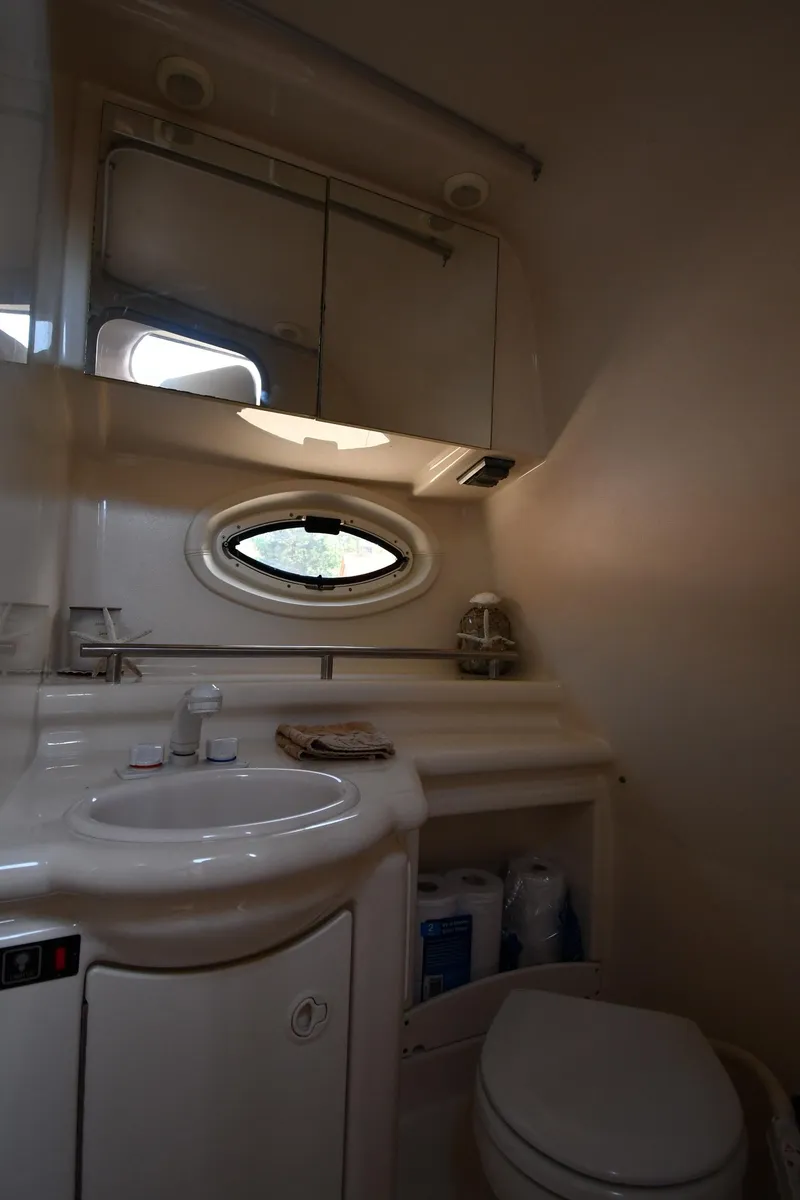 Slide: The Image of Compact bathroom in 2000 Maxum 2700 SCR boat with sink, mirror, and toilet. - 40
